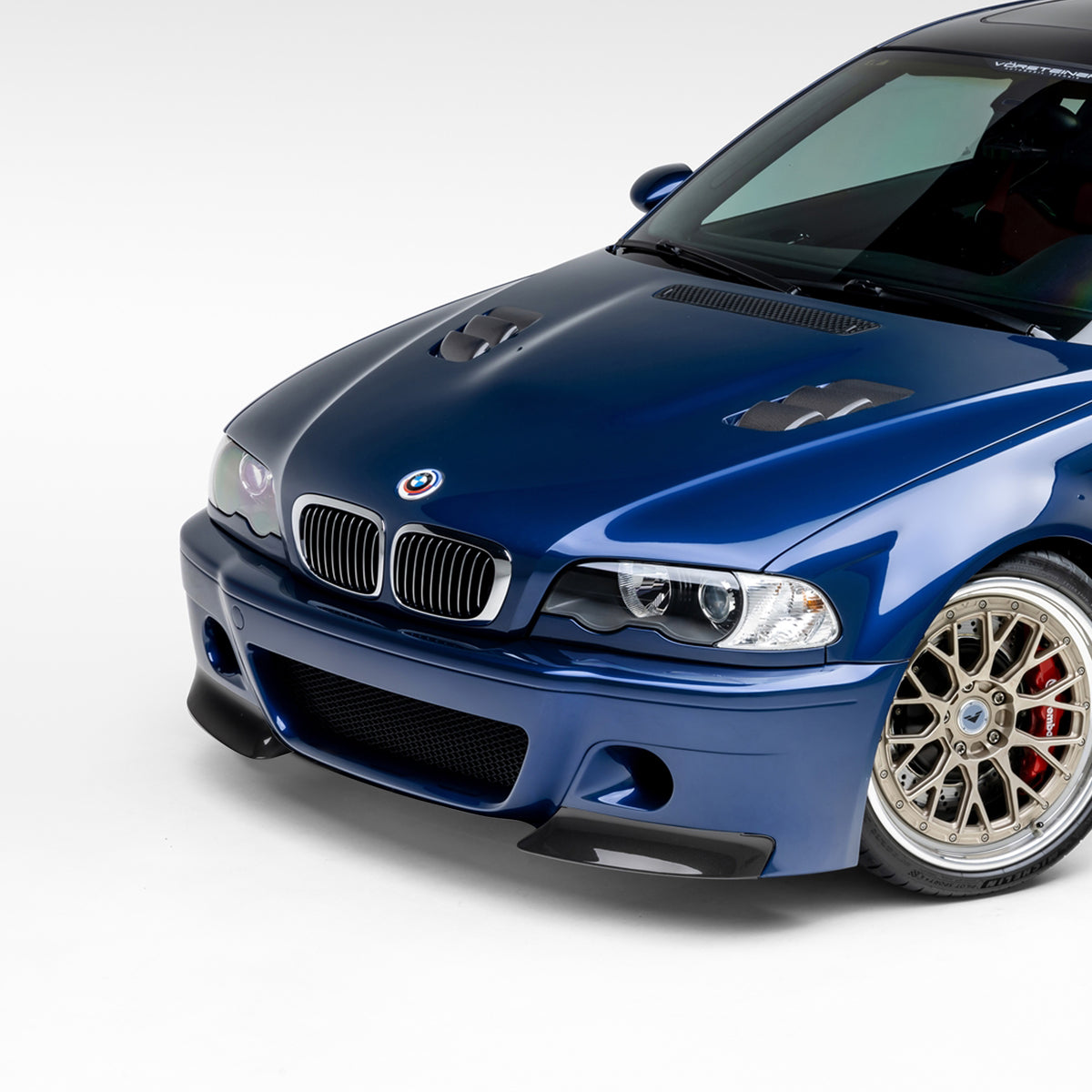 BMW E46 M3 V20 carbon fiber front bumper with 2-piece splitter, glossy aero upgrade by Vorsteiner Aerodynamics.