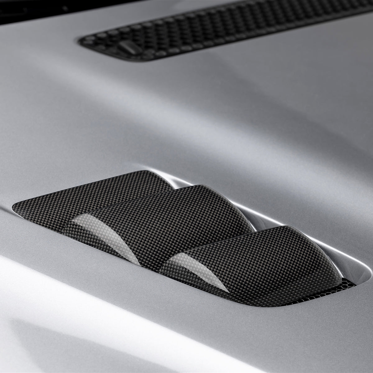 BMW E46 M3 V20 carbon fiber vented hood by Vorsteiner Aero, glossy finish, showcasing the lightweight, aerodynamic design.