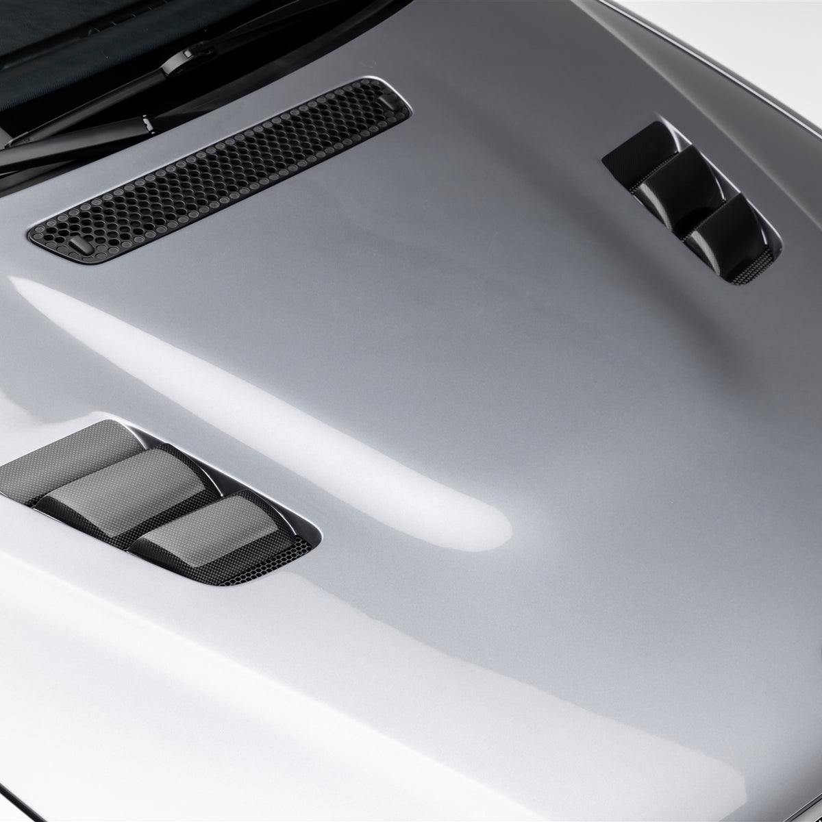 BMW E46 M3 V20 carbon fiber vented hood by Vorsteiner Aero, glossy finish with aerodynamic design.