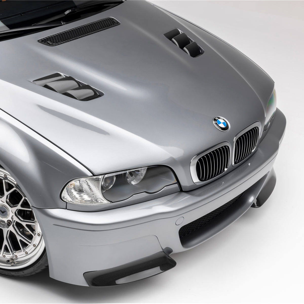 BMW E46 M3 V20 carbon fiber vented hood by Vorsteiner Aero, glossy 1x1 weave, showcasing aerodynamic design and vented features.
