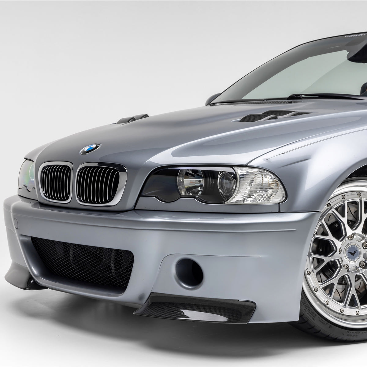 BMW E46 M3 V20 carbon fiber vented hood by Vorsteiner Aero, glossy finish, showing the aerodynamic design and vent openings.