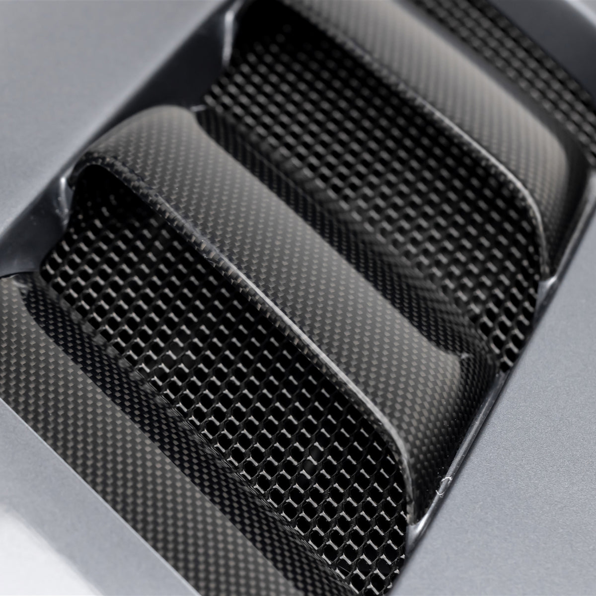 Glossy black Vorsteiner Aero V20 carbon fiber vented hood on a BMW E46 M3 (2000-2006) with distinctive vent design and smooth finish.