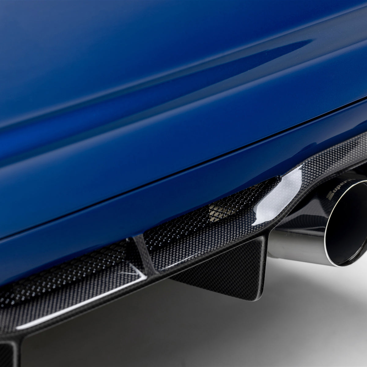 BMW E46 M3 V20 carbon fiber rear diffuser by Vorsteiner Aero, glossy 1x1 finish, enhances vehicle aerodynamics and sporty look