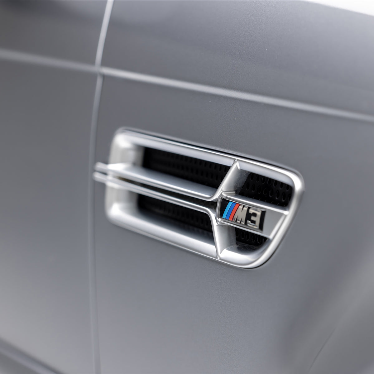 Nickel-plated aero side grilles for BMW E46 M3 V20 by Vorsteiner Aerodynamics, showcasing sleek, chrome finish on vehicle sides.