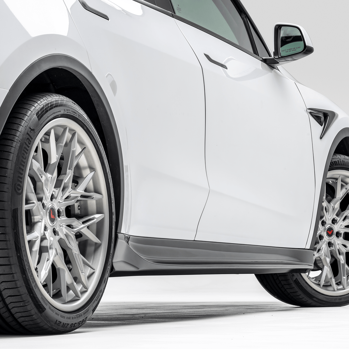 Tesla Model Y aero side skirts by Vorsteiner Aerodynamics, showcasing sleek, aerodynamic design on the vehicle's sides.
