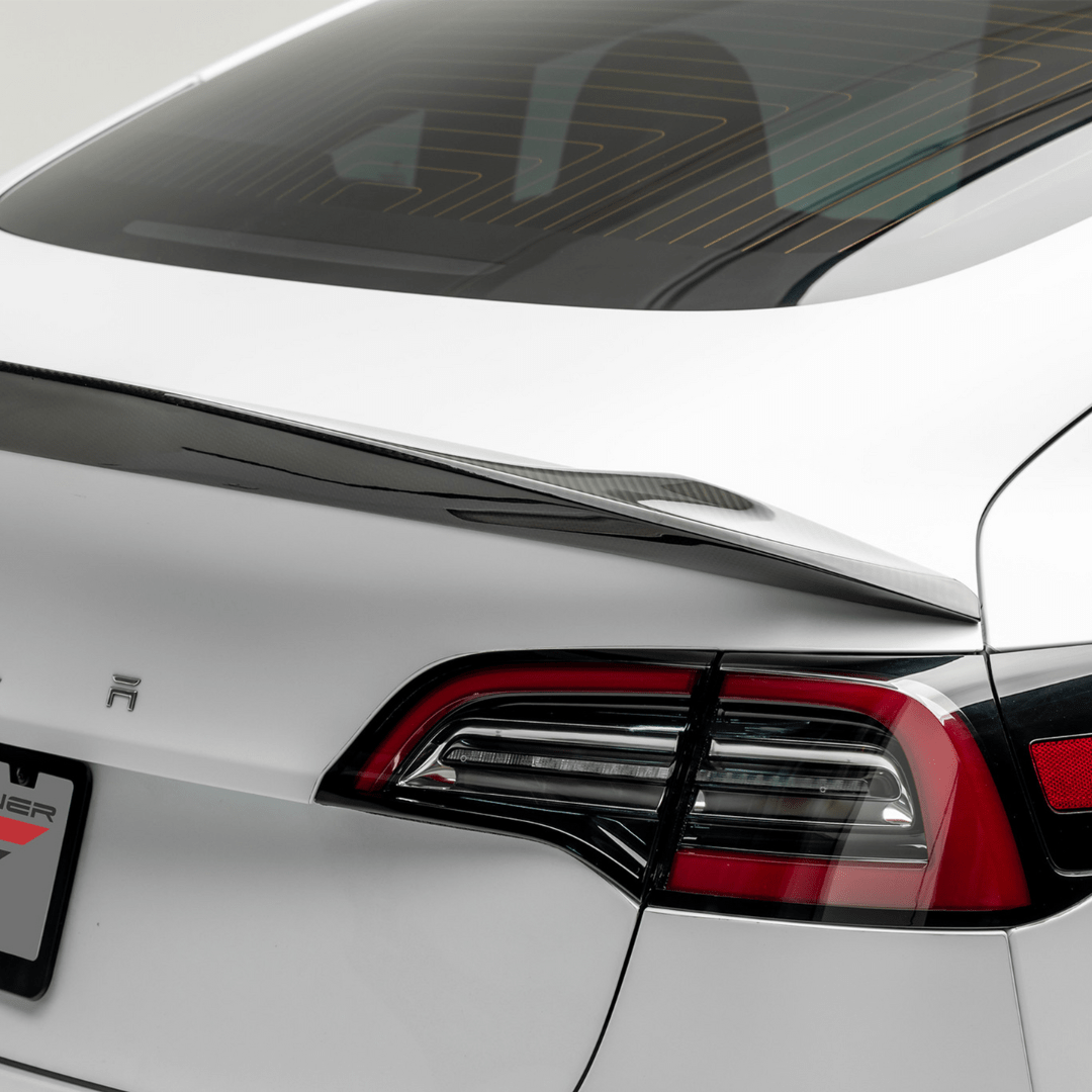 Tesla Model 3 Volta Aero Decklid Spoiler by Vorsteiner Aerodynamics, showcasing a sleek carbon fiber design on the car's rear.